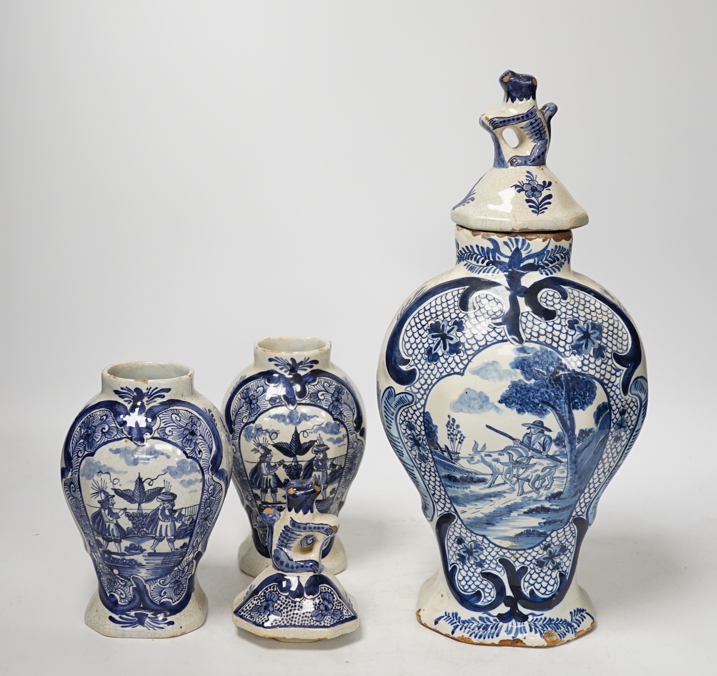 An 18th century Delft blue and white vase and a pair of later Delft vases and covers, tallest 23.5cm